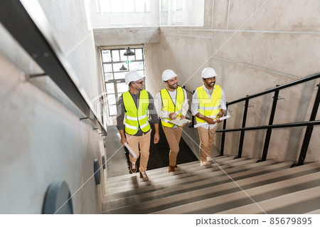 architects in helmets walking upstairs at office 85679895