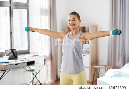 teenage girl with dumbbells exercising at home 85679899