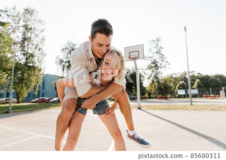 happy couple having fun on basketball playground 85680311
