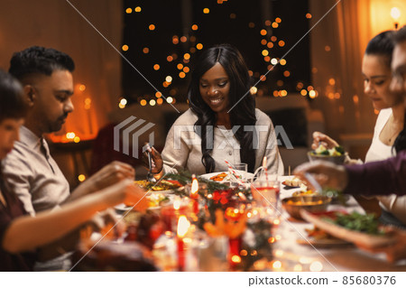 happy friends having christmas dinner at home happy friends having christmas dinner at home 85680376