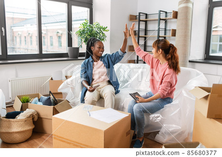 happy women moving to new home and counting money happy women moving to new home and counting money 85680377