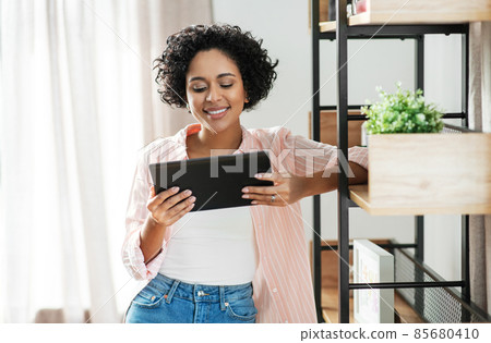 smiling woman with tablet pc computer at home smiling woman with tablet pc computer at home 85680410