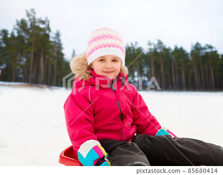 happy little girl on sled outdoors in winter happy little girl on sled outdoors in winter 85680414