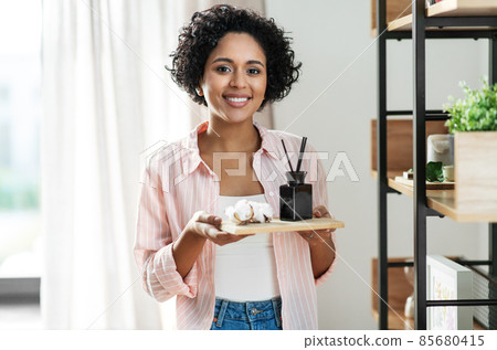 woman with aroma reed diffuser and cotton at home 85680415