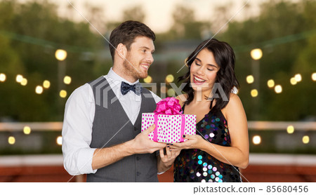 happy couple with gift box at birthday party happy couple with gift box at birthday party 85680456