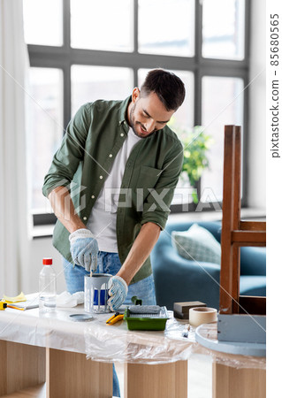 man stirring can with grey color paint at home man stirring can with grey color paint at home 85680565