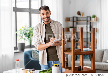 man with old table writing to notebook at home man with old table writing to notebook at home 85680588