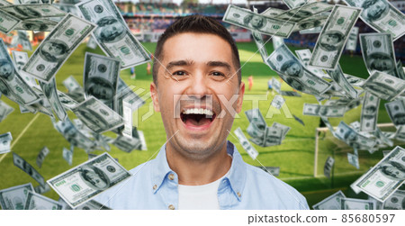 happy man over money rain on football field 85680597