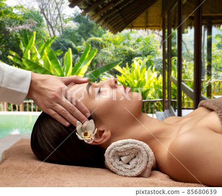 woman having face and head massage at spa woman having face and head massage at spa 85680639
