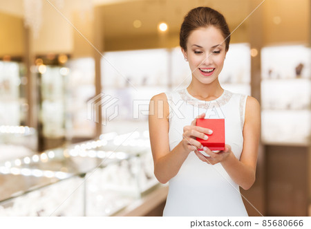 smiling woman with red gift box at jewelry store smiling woman with red gift box at jewelry store 85680666
