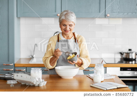 happy woman cooking food on kitchen at home 85680772