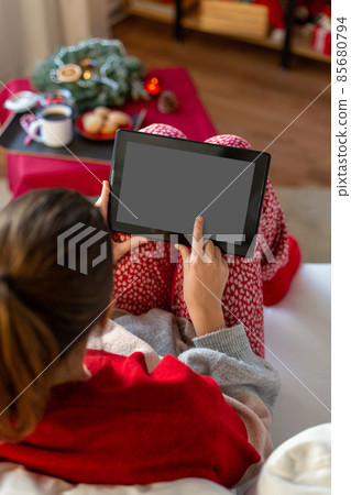 woman with tablet computer at home on christmas woman with tablet computer at home on christmas 85680794