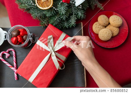 hand with christmas gift, treats and decorations hand with christmas gift, treats and decorations 85680852