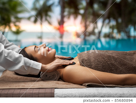 beautiful woman having hot stone massage at spa 85680894