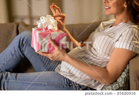 happy smiling pregnant woman with gift box at home happy smiling pregnant woman with gift box at home 85680916