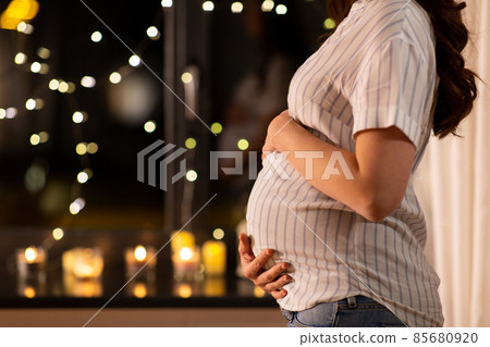 close up of pregnant woman at window at home close up of pregnant woman at window at home 85680920