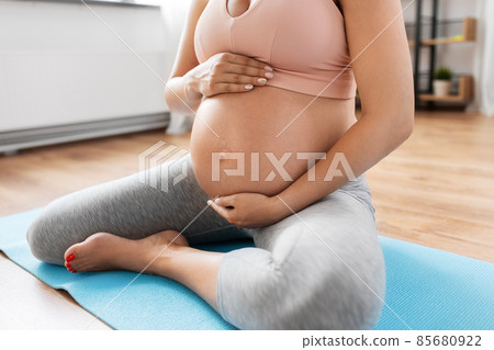 close up of pregnant woman doing yoga at home close up of pregnant woman doing yoga at home 85680922