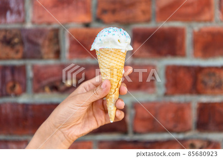close up of hand holding waffle ice cream cone close up of hand holding waffle ice cream cone 85680923