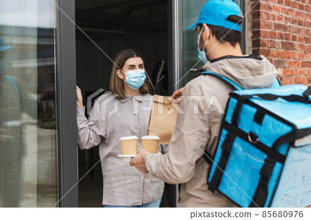 food delivery man in mask giving order to customer food delivery man in mask giving order to customer 85680976
