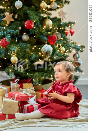 happy baby girl opening christmas gifts at home 85681033