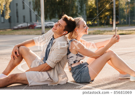 happy couple with smartphone and earphones in city happy couple with smartphone and earphones in city 85681069