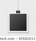 Photo frame with shadow hanging with paper clip. Black square snapshot and metal blinder.  85682613