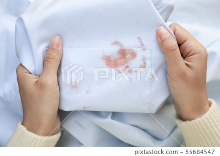 Hand showing dirty cosmetic stain on white shirt from unexpected accident. daily life stain concept Hand showing dirty cosmetic stain on white shirt from unexpected accident. daily life stain concept 85684547