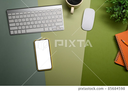 Smart phone, coffee cup, notebook and houseplant on green background. 85684598