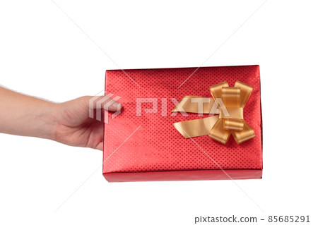 Red gift box with golden bow in hand. Red gift box with golden bow in hand. 85685291
