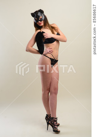 Young caucasian female in black underwear wearing a cat mask. Young caucasian female in black underwear wearing a cat mask. 85686617