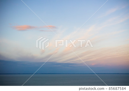 Tranquil nature scenery with long clouds covering blue sky Tranquil nature scenery with long clouds covering blue sky 85687584