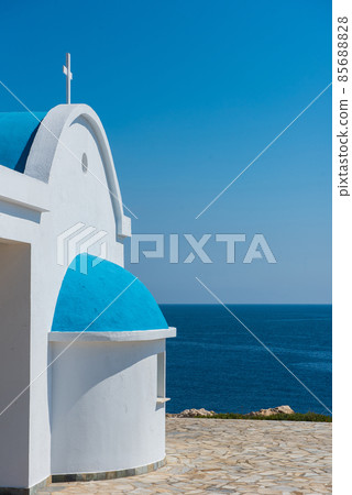 Traditional white chapel with a blue roof on the seaside. Agioi Anargyroi, Cyprus 85688828