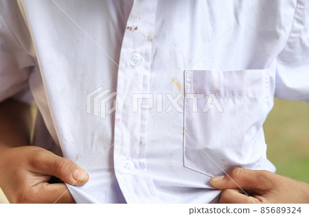 Kid showing dirty stain on cloth from long playing in daily life fpr cleaning concept 85689324
