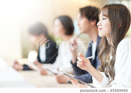 A young woman taking notes on a tablet while taking a seminar A young woman taking notes on a tablet while taking a seminar 85689400