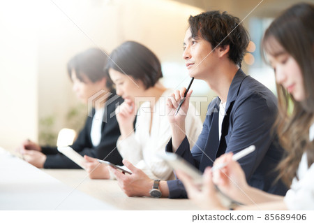 A young man taking notes while taking a seminar 85689406