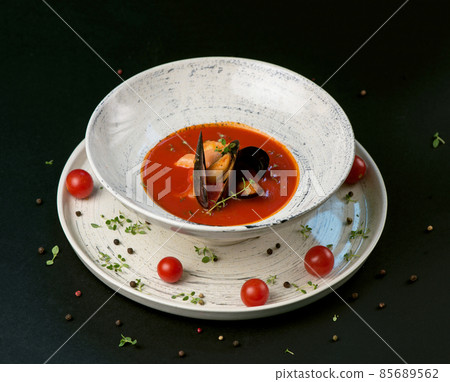 Fish soup, norman fish soup bouillabaisse with seafood in a plate on a black background 85689562