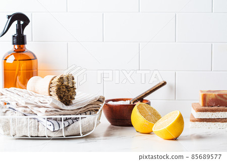 Eco home cleaning. Natural brushes, sponges and organic cleaning products on white kitchen table. Zero waste concept. 85689577