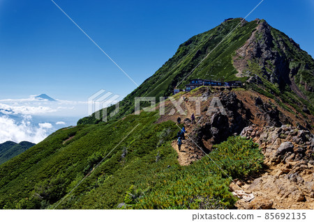 View of Mt. Aka and Mt. Fuji with climbers going along the Yatsugatake ridge 85692135