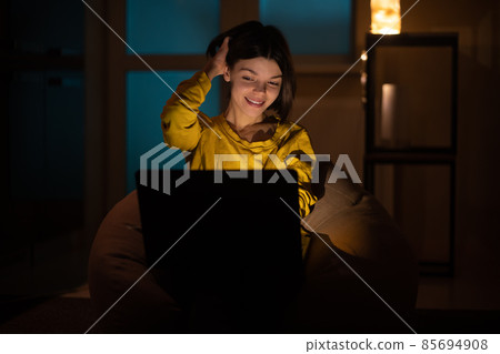 .The girl is surprised. She works on a laptop at home. 85694908