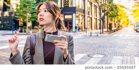 A young business woman checking a map on her smartphone in Tokyo Marunouchi 85695087