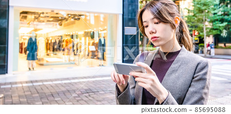 A young business woman checking a map on her smartphone in Tokyo Marunouchi 85695088