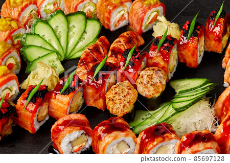 Closeup set of rolls, nigiri sushi and gunkan maki with salmon on black background Closeup set of rolls, nigiri sushi and gunkan maki with salmon on black background 85697128