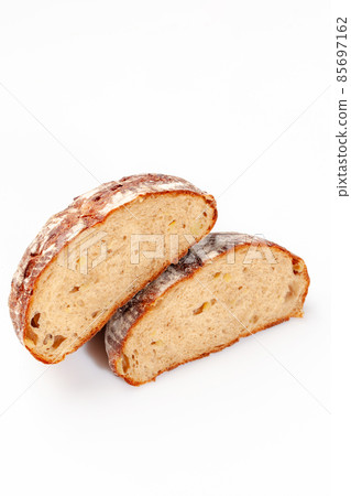 Round wheat bread with cheese inside cut in half on white background 85697162