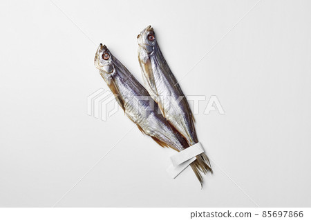 Two salted air-dried sabrefish with paper labels on tails isolated on white 85697866