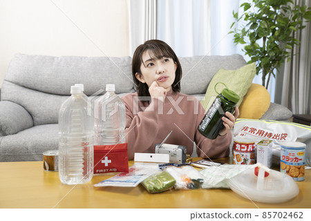 A woman checking the contents of an emergency carry-out bag 85702462