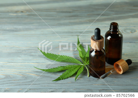 Cannabis leaf and oil on gray wooden background Cannabis leaf and oil on gray wooden background 85702566
