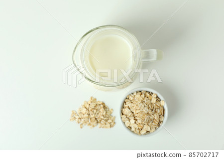 Pitcher of milk and cereals on white background 85702717