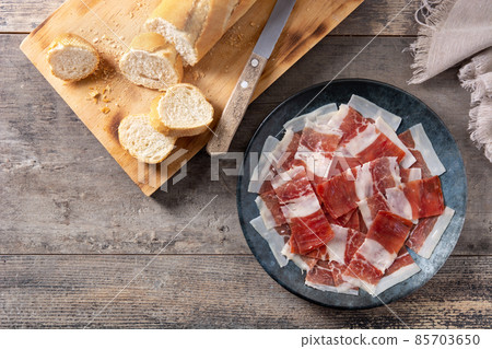 Spanish serrano ham slices on black plate Spanish serrano ham slices on black plate 85703650