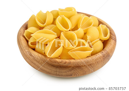Uncooked dried conchiglie in wooden bowl. Raw organic shell pasta isolated on white bachground with clipping path and full depth of field 85703737