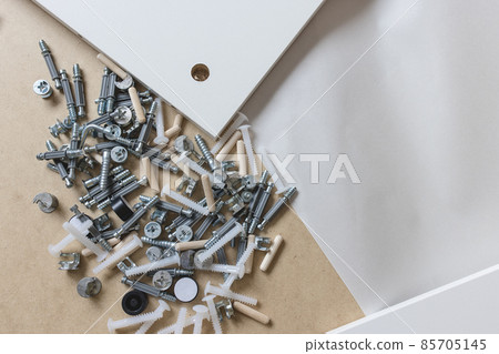 Opened box with furniture assembly parts, closeup Opened box with furniture assembly parts, closeup 85705145